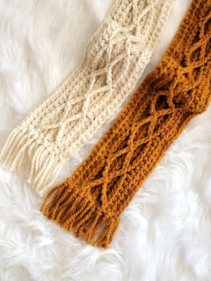 A pair of crochet cable scarves in cream and mustard colors