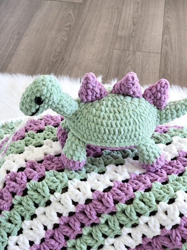 Crochet dinosaur in purple and green color with matching blanket