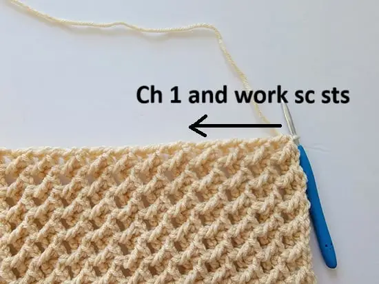 Arrow showing where to distribute sc stitches