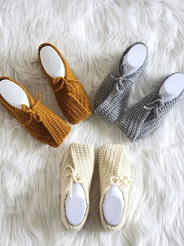 3 pair of women's crochet slippers in cream, yellow and gray.