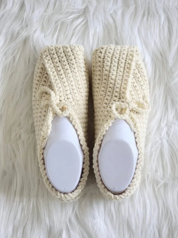A pair of cream crochet slippers