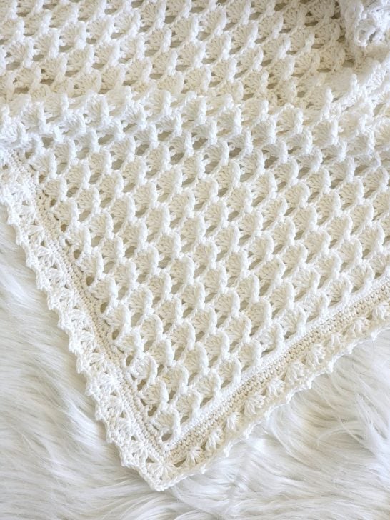 Gender neutral crochet baby blanket pattern finished in white color