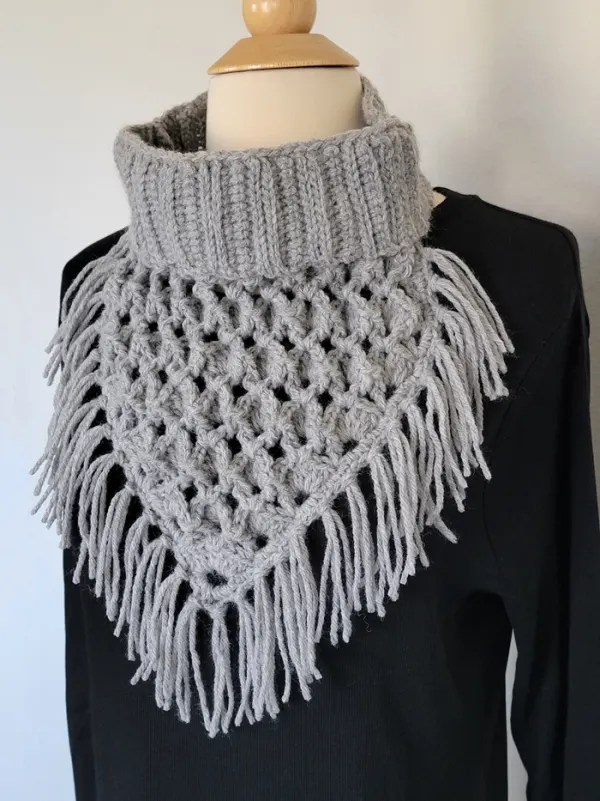 Crochet bandana cowl in grey color with fringes on a mannequin wearing black top