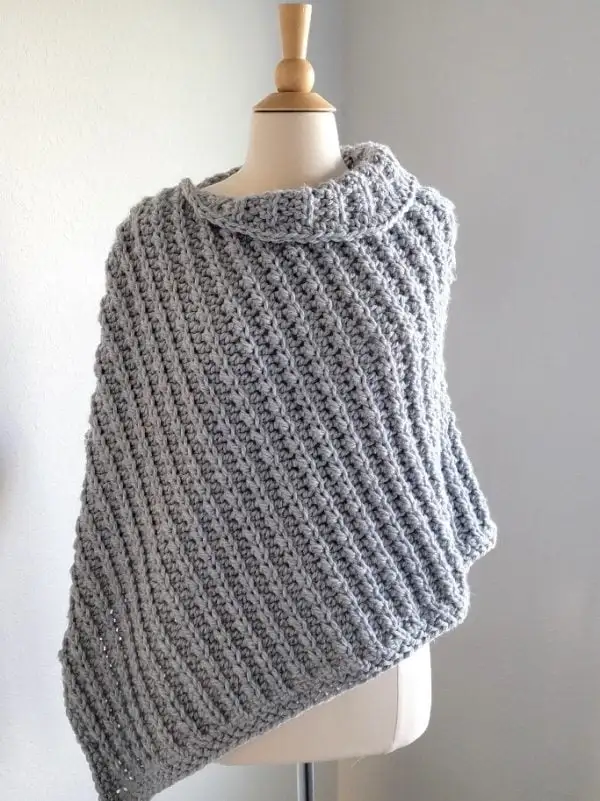 chunky crochet poncho in gray color with collar on a manequin