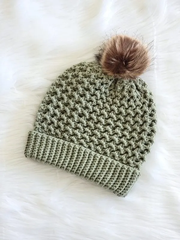 crochet hat in green color with fur pom pom