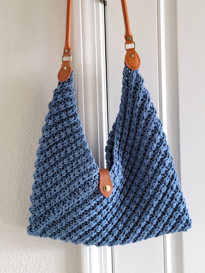 Crochet Hobo Bag hanging on a white door