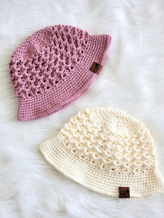 crochet bucket hats in cream and dusty pink displayed on fur fabric
