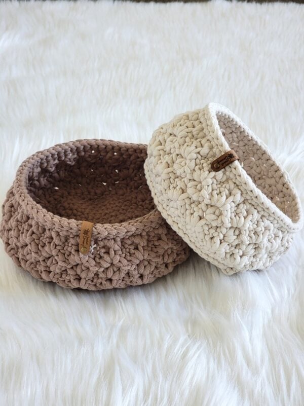 Two crochet baskets, one placed on side of the other