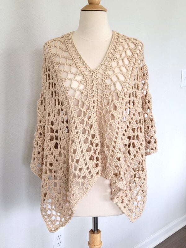 Lacy crochet poncho on a mannequin with V-neck