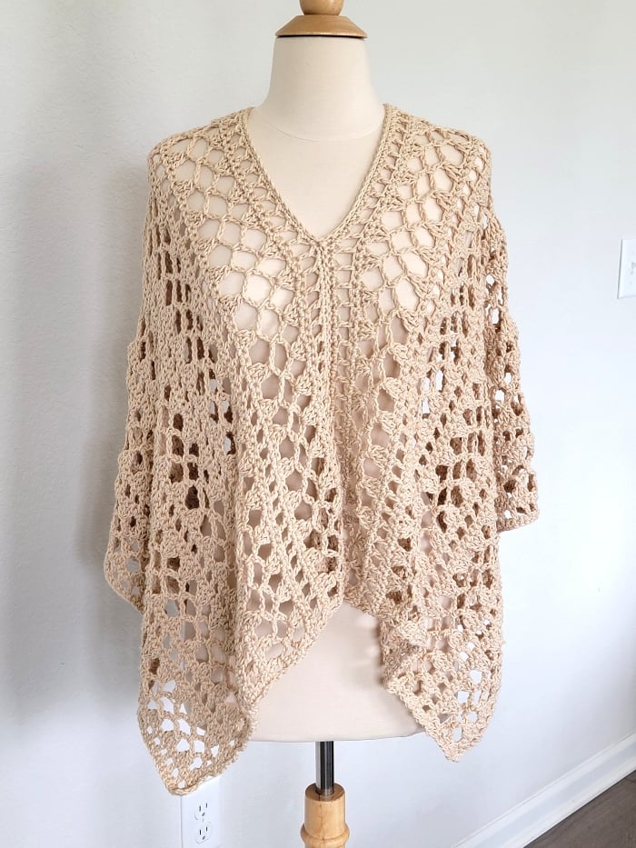 Lacy crochet poncho on a mannequin with V-neck
