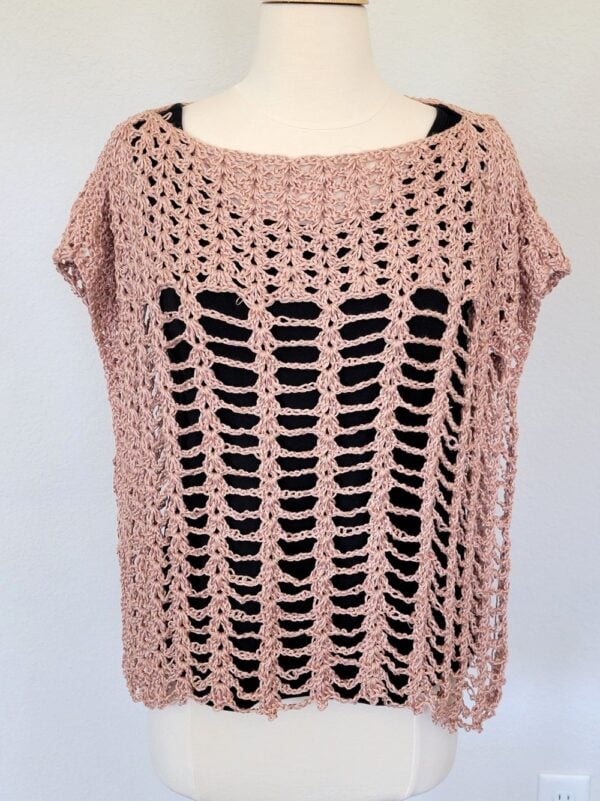 Crochet poncho worn over a black tank top