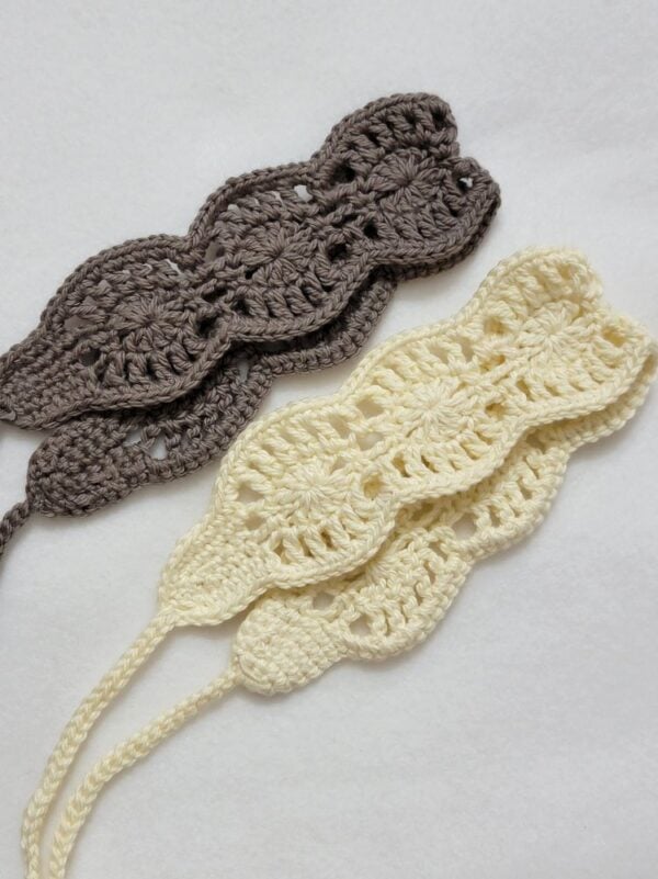 Two crochet summer headbands with scalloped floral motifs in cream and taupe, featuring long ties for an adjustable fit.