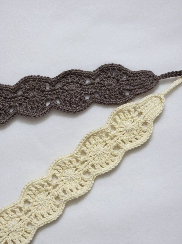 Close-up of cream and taupe crochet headbands featuring a delicate lacy floral stitch pattern with scalloped edges.