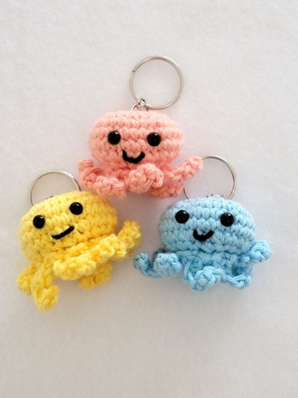 Crochet octopus keychains in peach blue and yellow colors