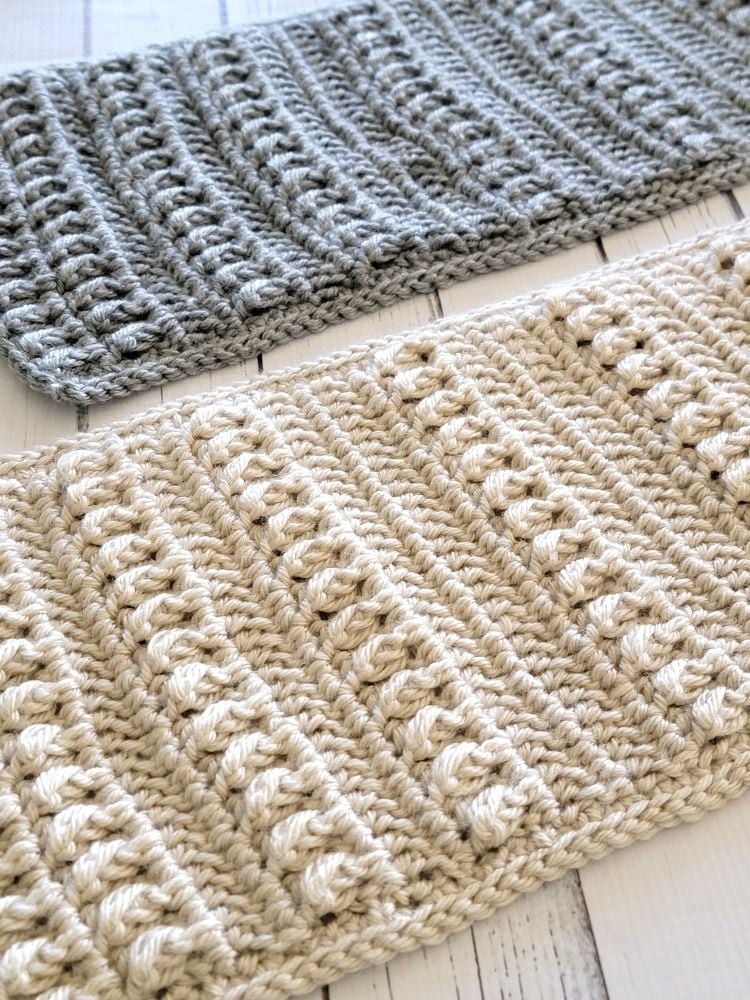 Close-up of cream and gray unisex or men's crochet scarves with raised textured stitches.