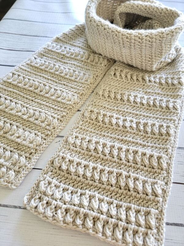 Cream men's crochet scarf laid flat to show the textured ends