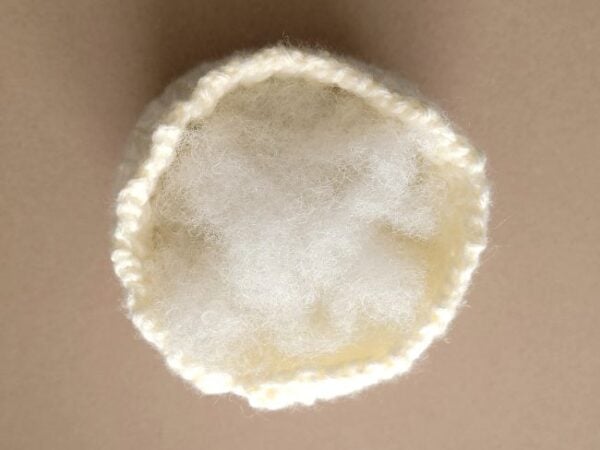 Top view of the cream crochet pumpkin filled with white fiberfill stuffing.