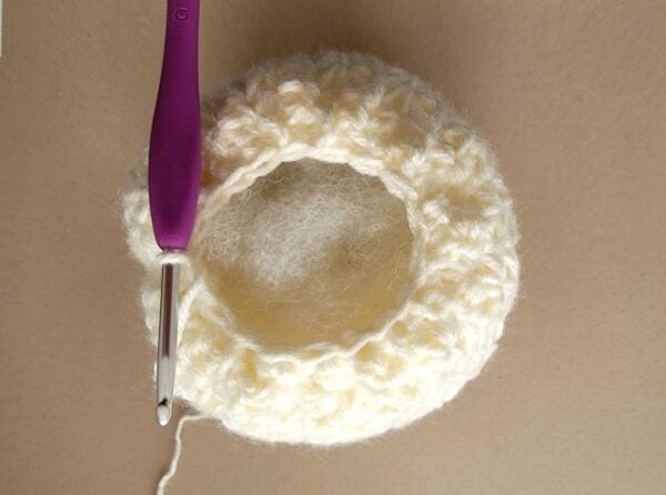 A purple hook shown at the top opening of the pumpkin with fiber fill inside