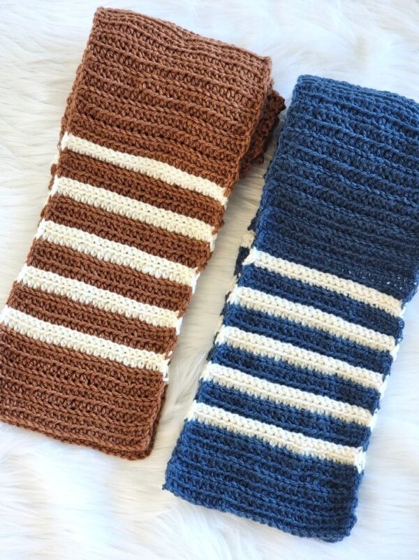 Brown and navy striped crochet scarves with cream accent stripes laid side by side on a white background.